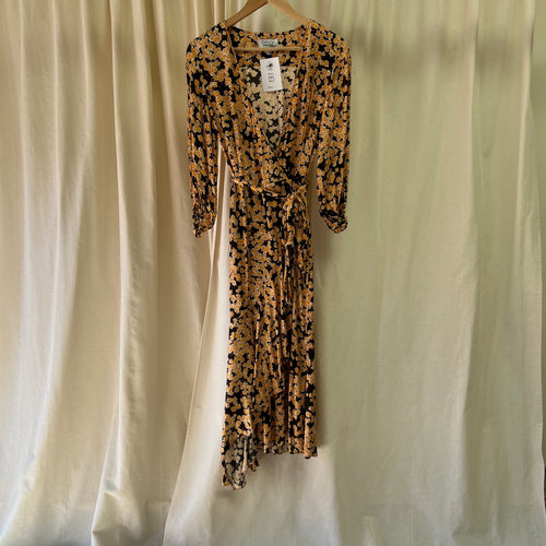 Floral dress on a hanger against a plain background