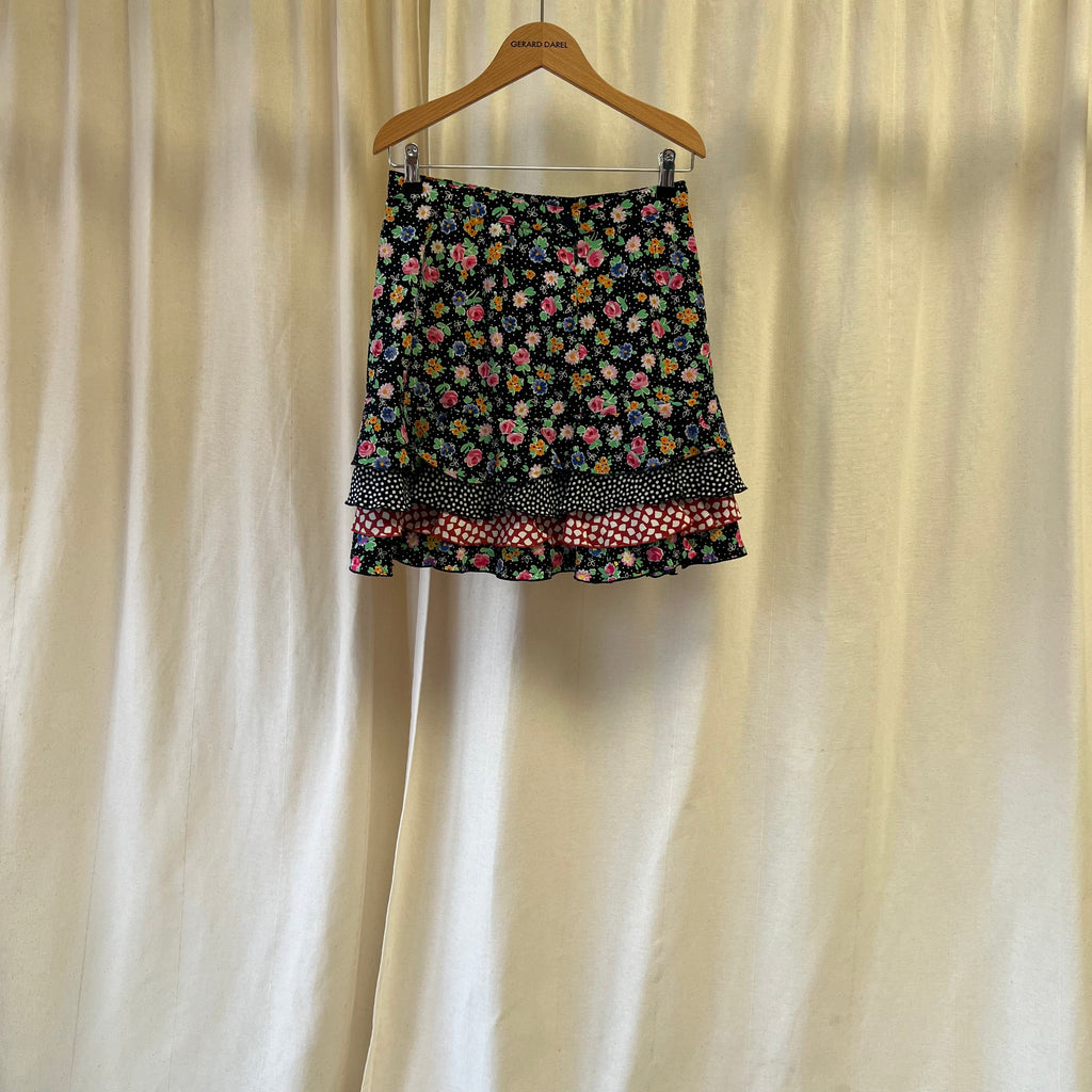 Floral patterned skirt on a hanger against a plain background