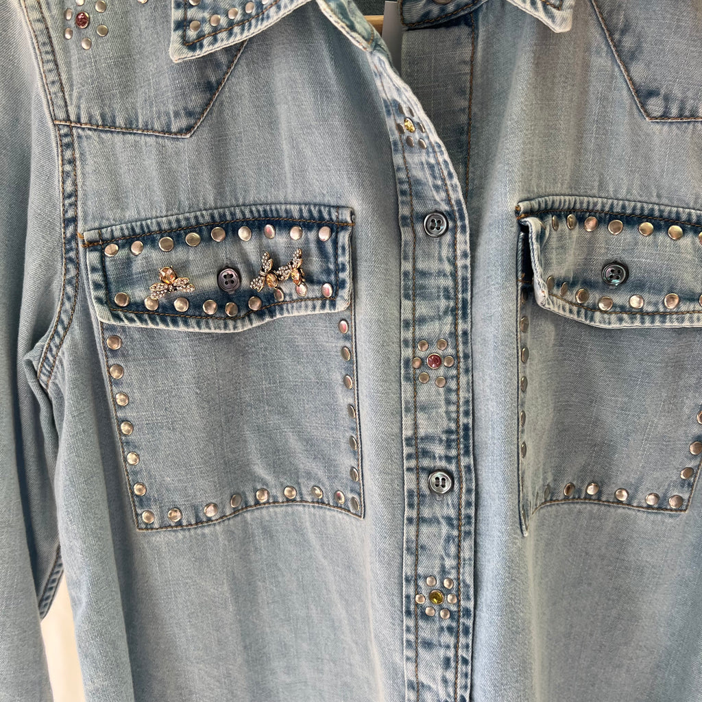 Denim shirt with studded details on a plain background