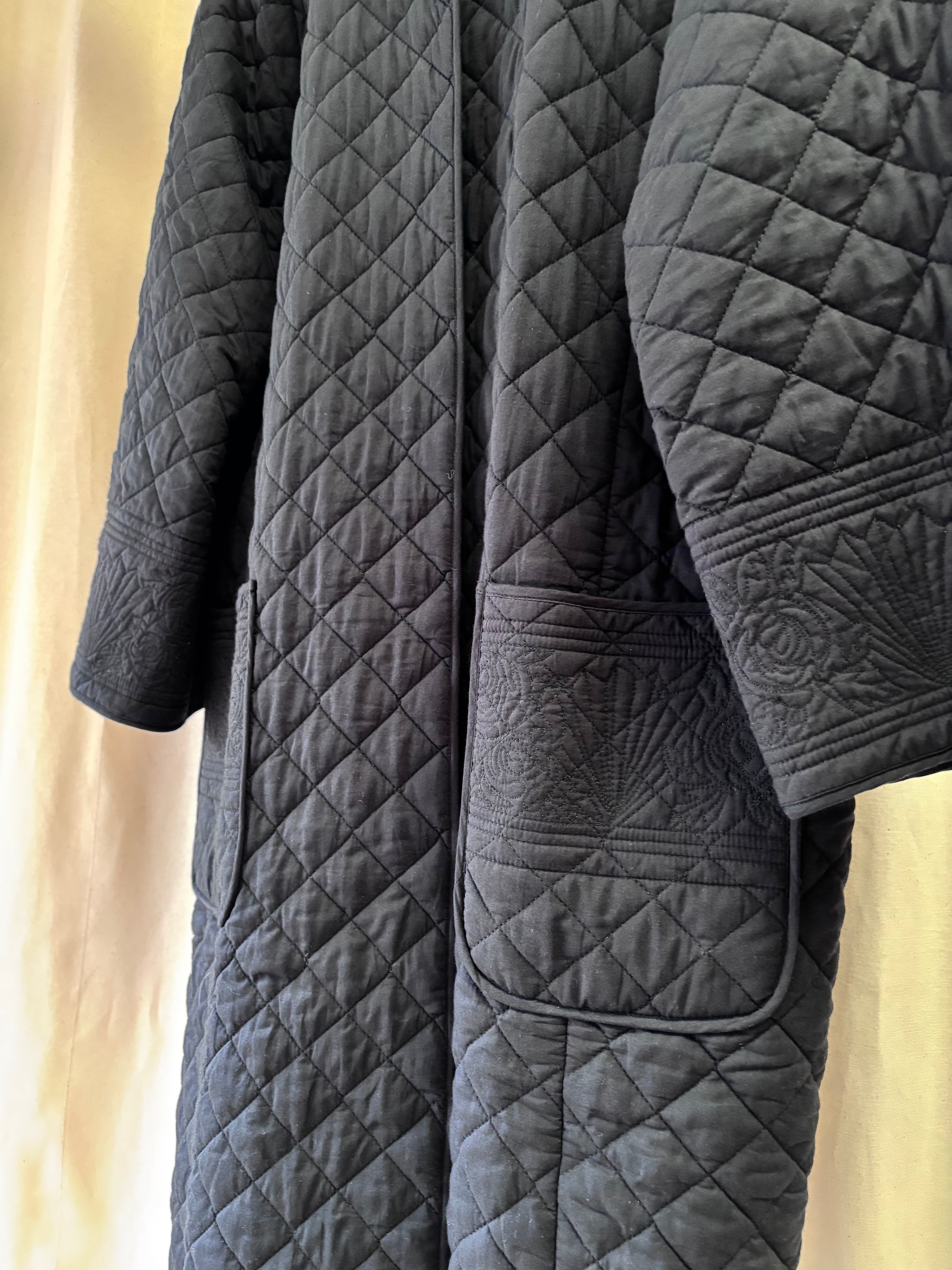 Quilted gray blanket with diamond pattern on a beige background