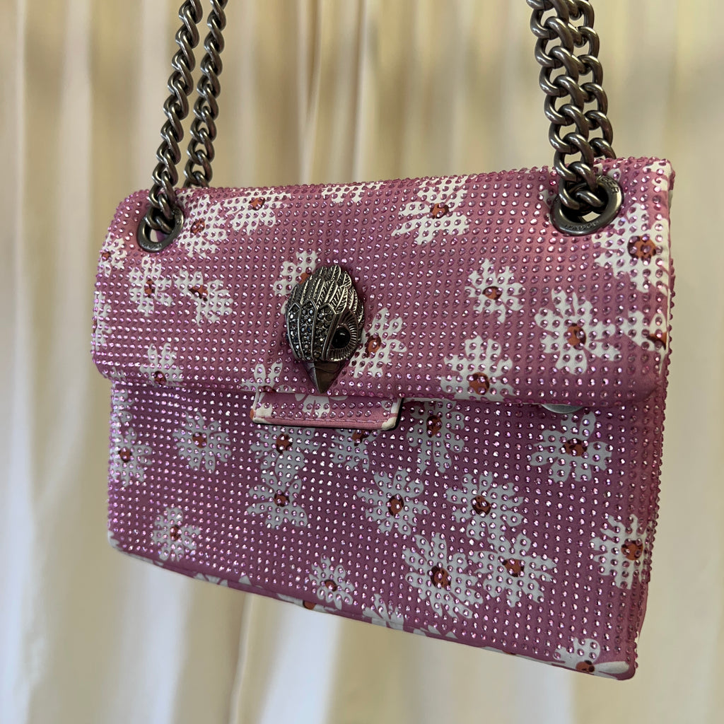 Purple floral patterned handbag with chain strap on a light background