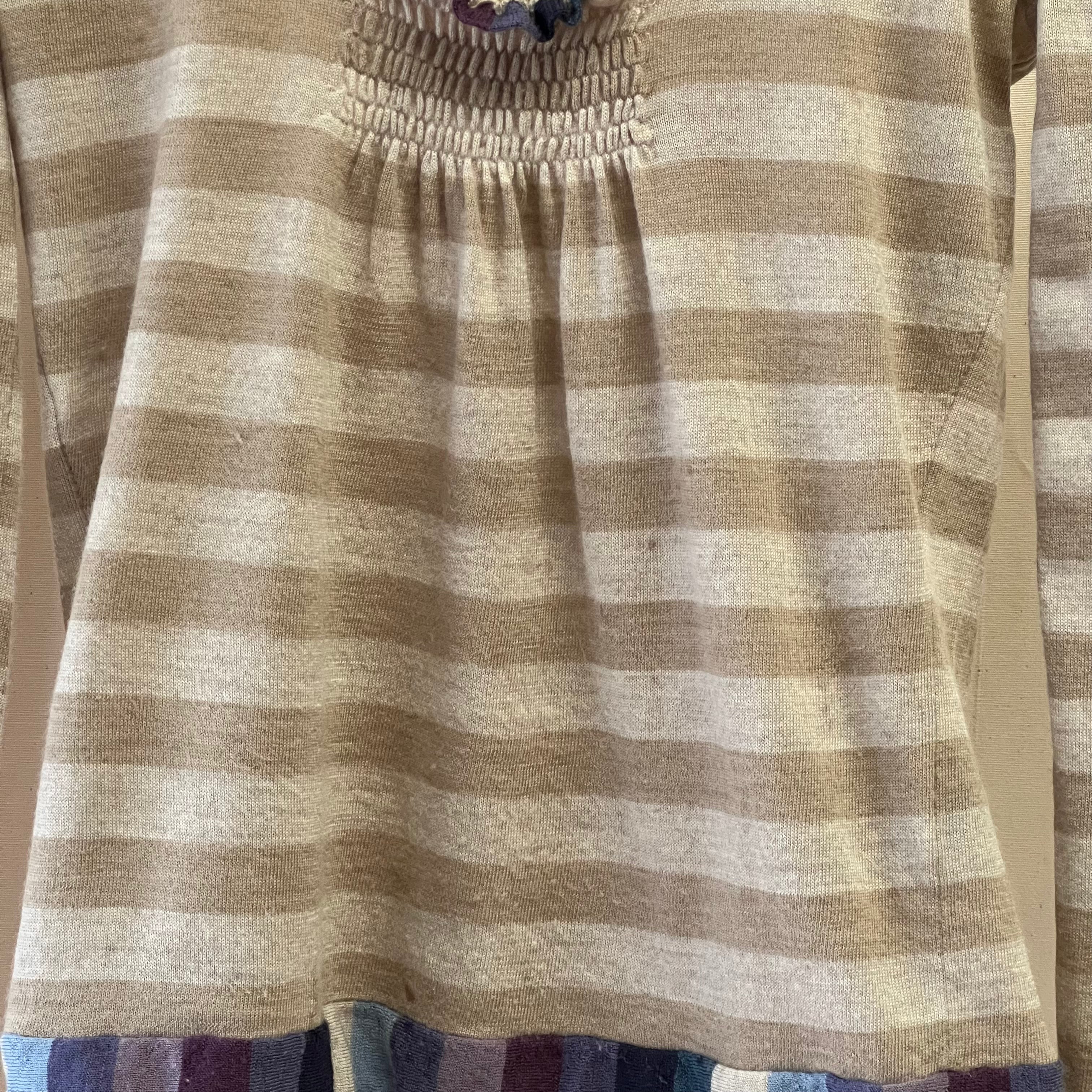 Striped dress with smocked waistband on a plain background