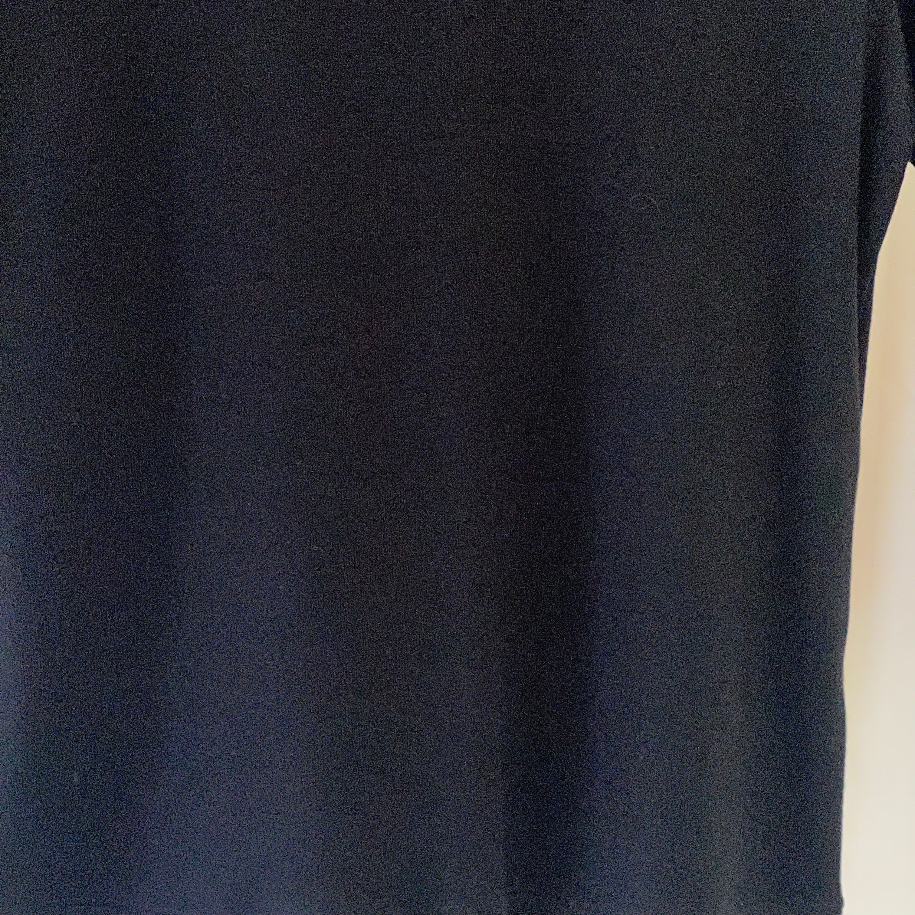 Close-up of a black t-shirt on a light beige background