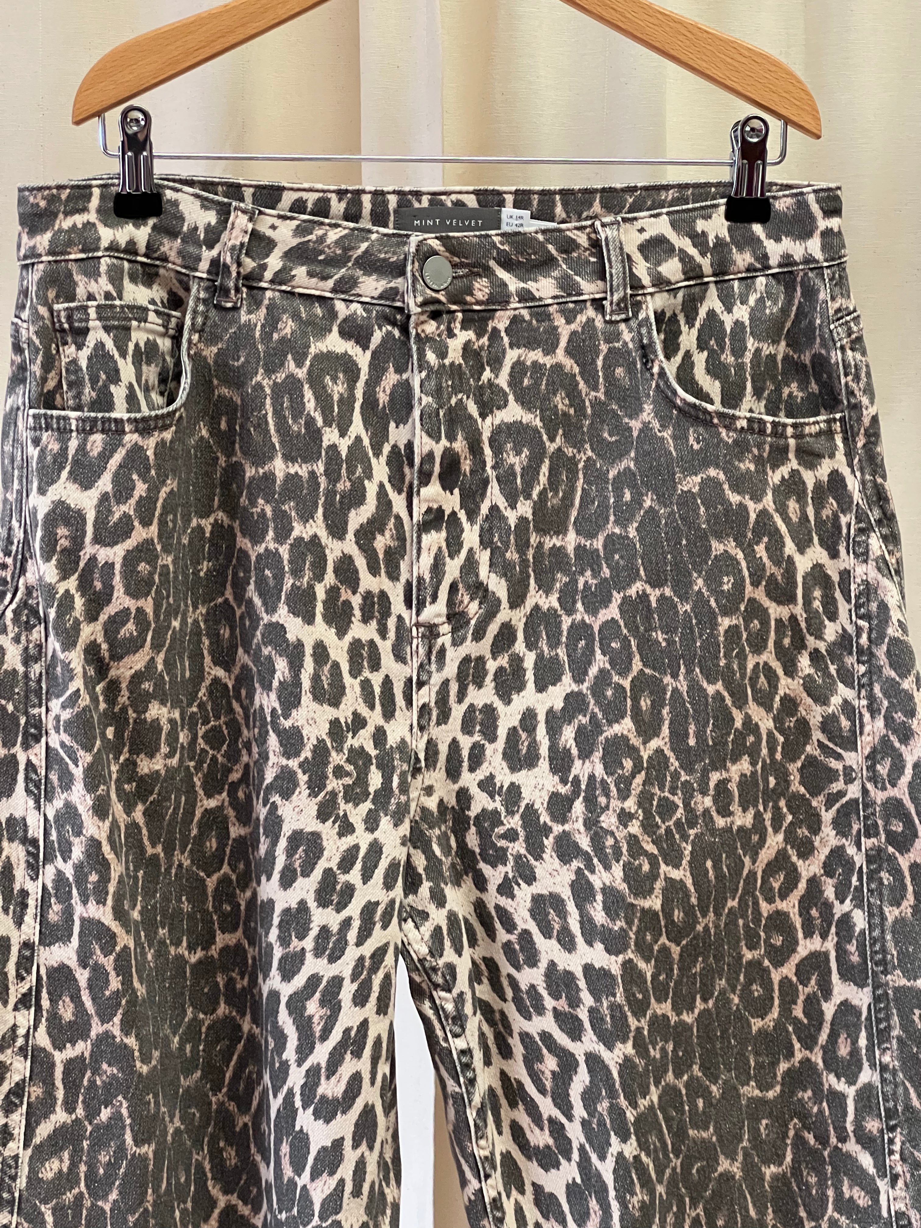 Leopard print pants on a hanger against a white background