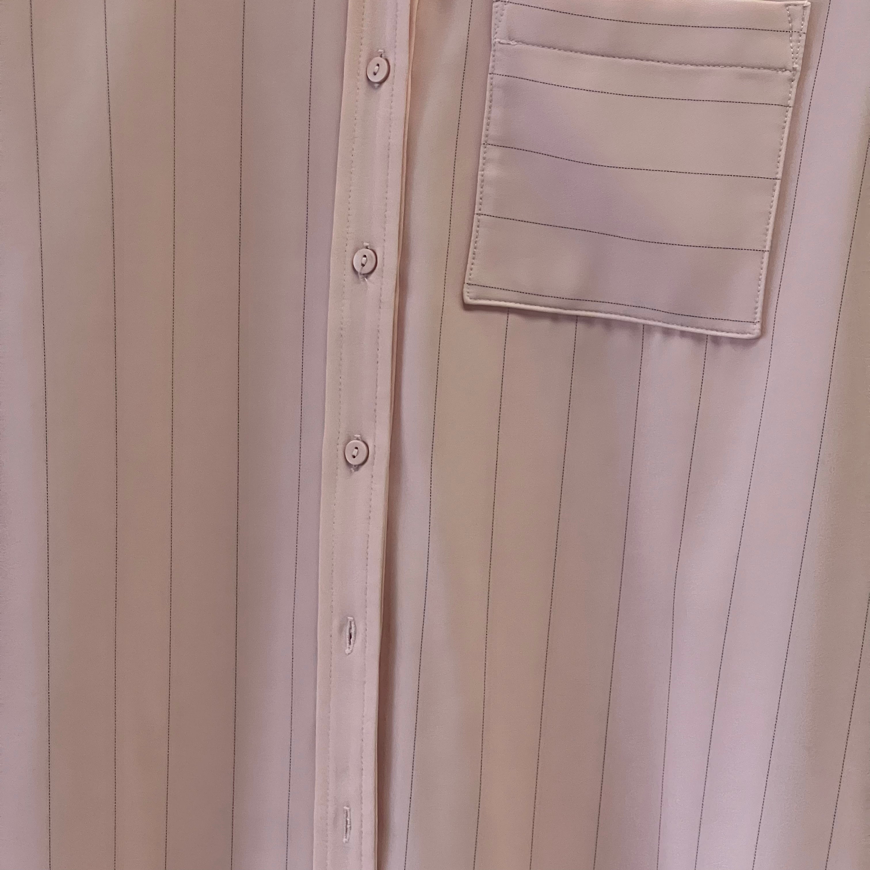 Close-up of a beige button-up shirt with a pocket