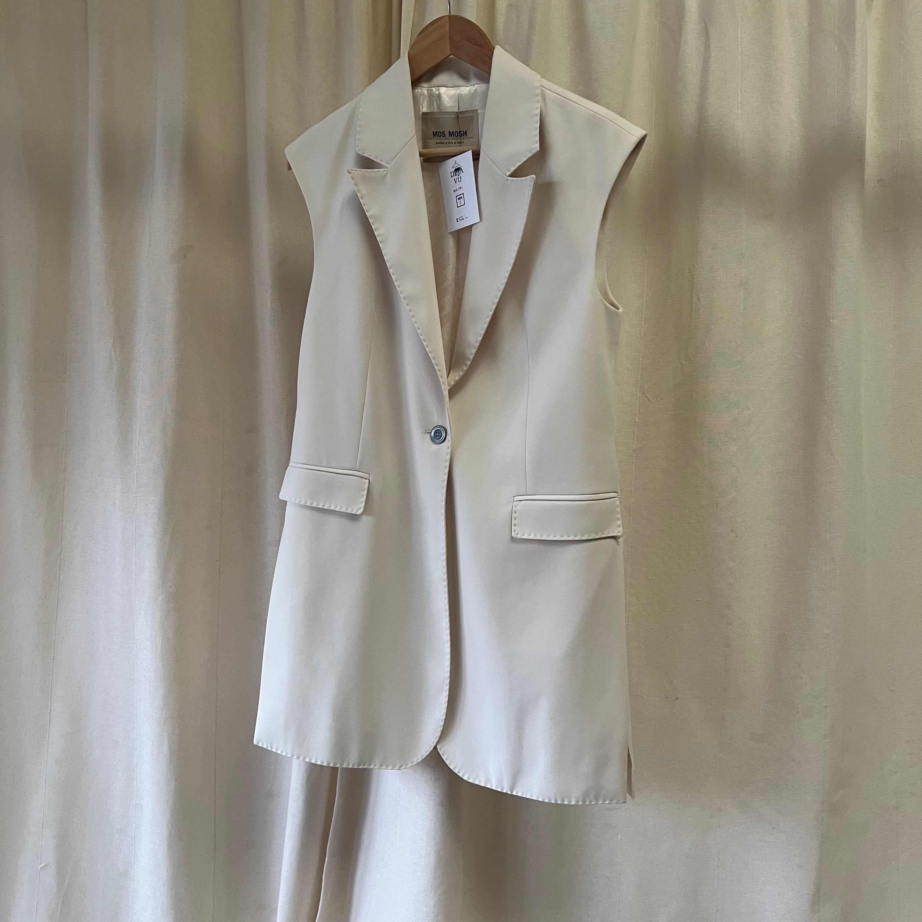 Beige blazer on a hanger against a plain background