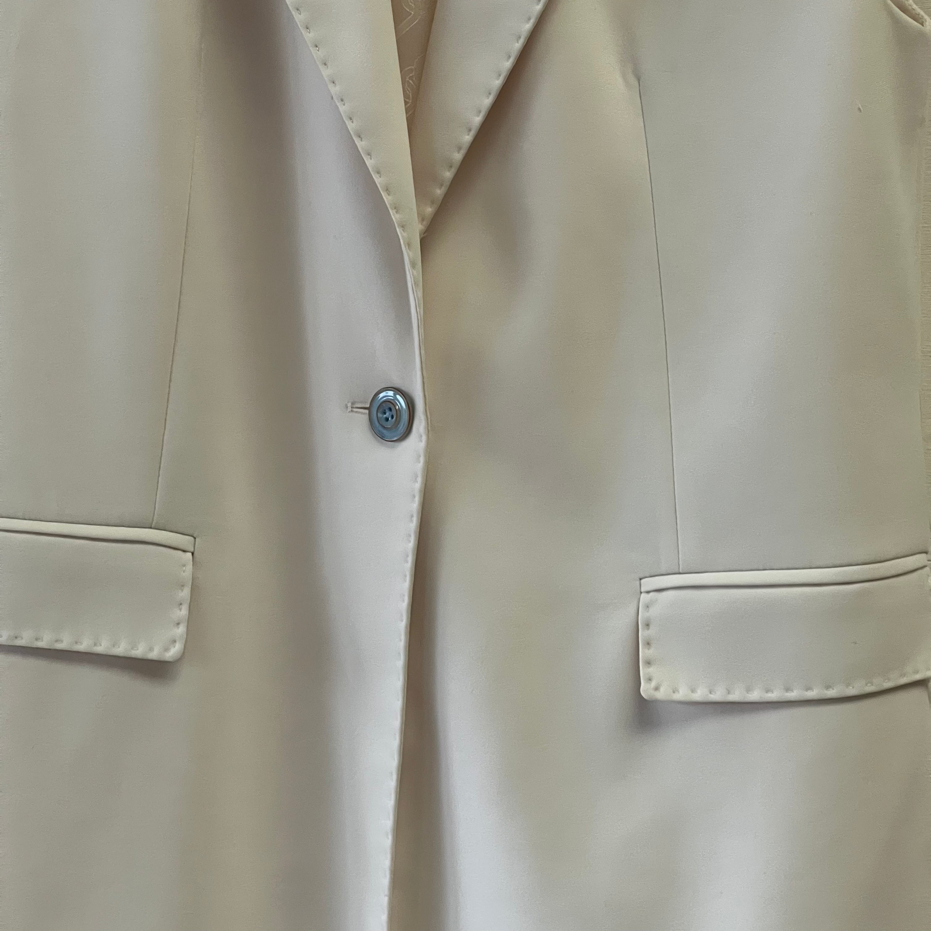 Close-up of a beige trench coat with a button detail
