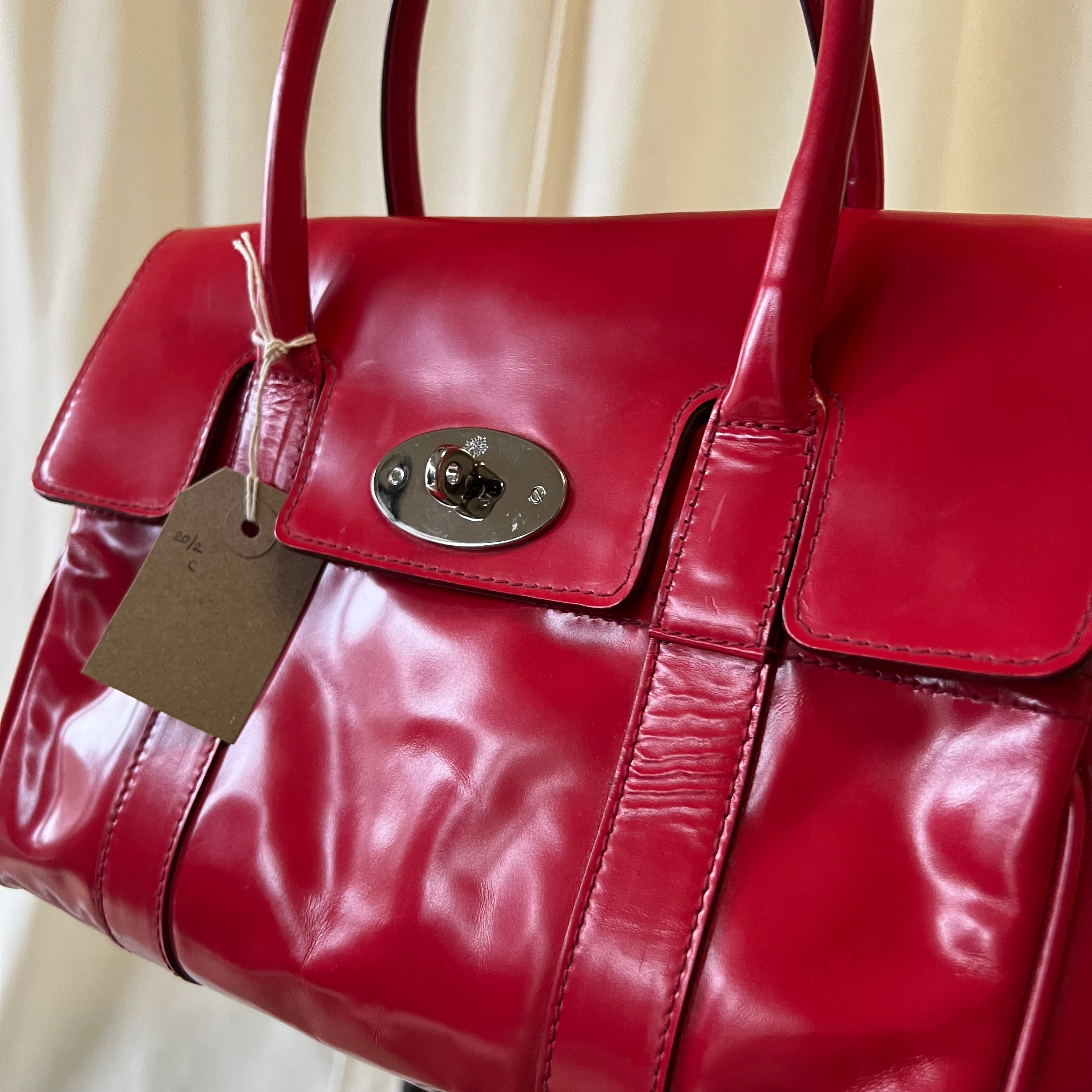 Red leather handbag with a tag on a light background
