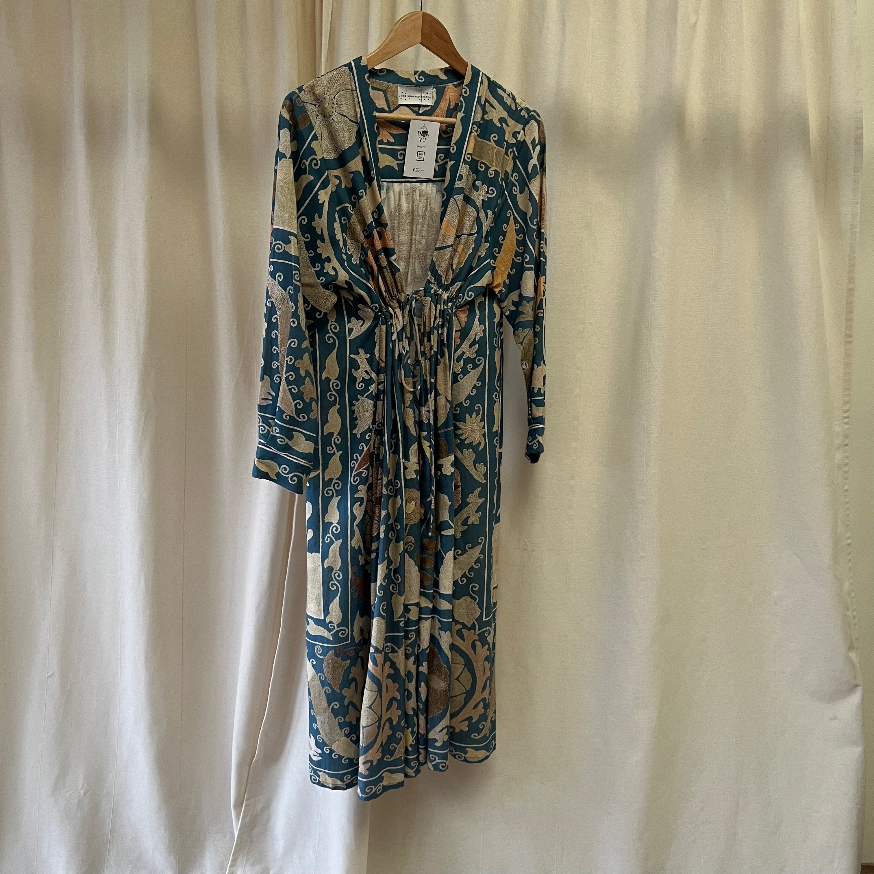 Patterned dress on a hanger against a plain background