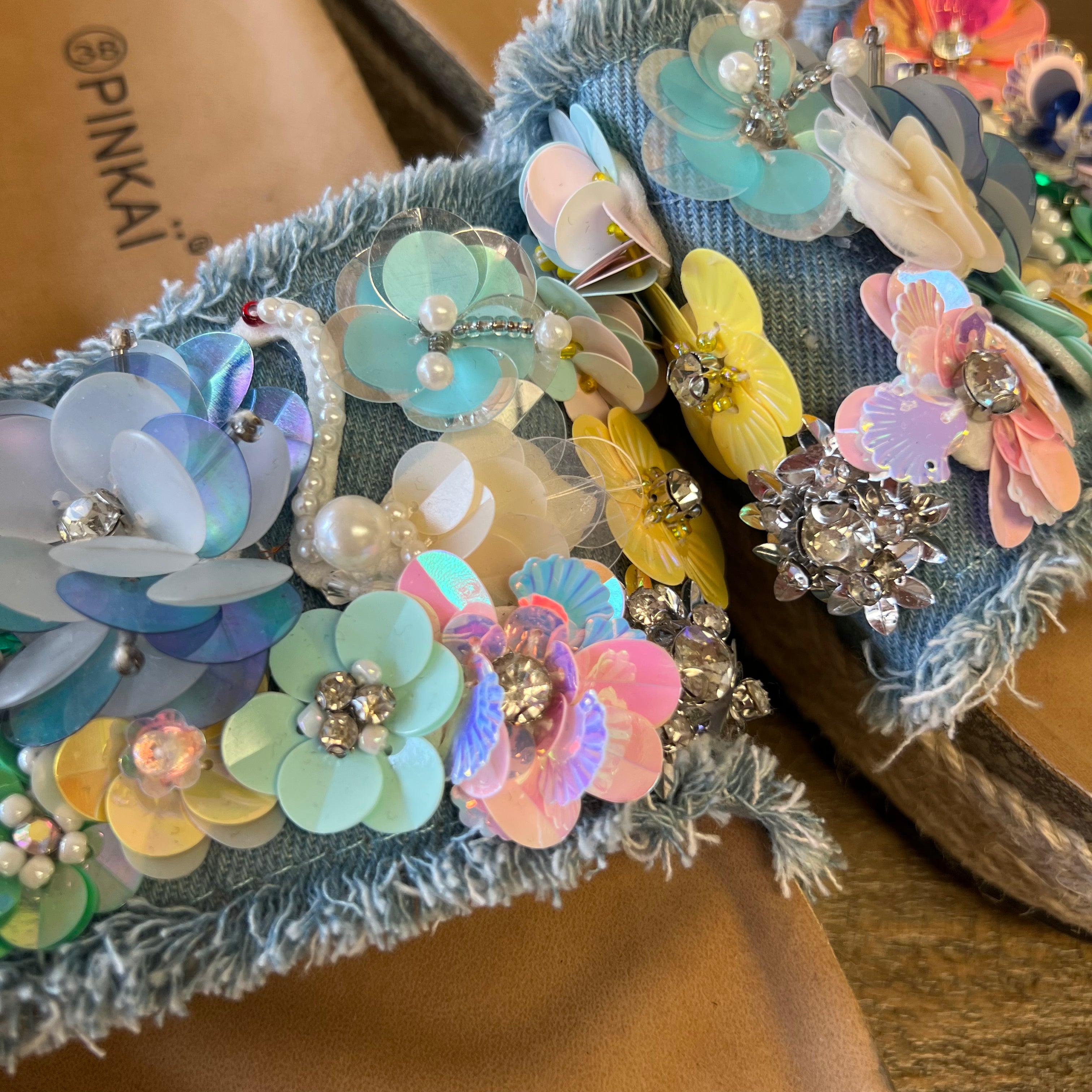 Colorful floral headbands with embellishments on a brown surface