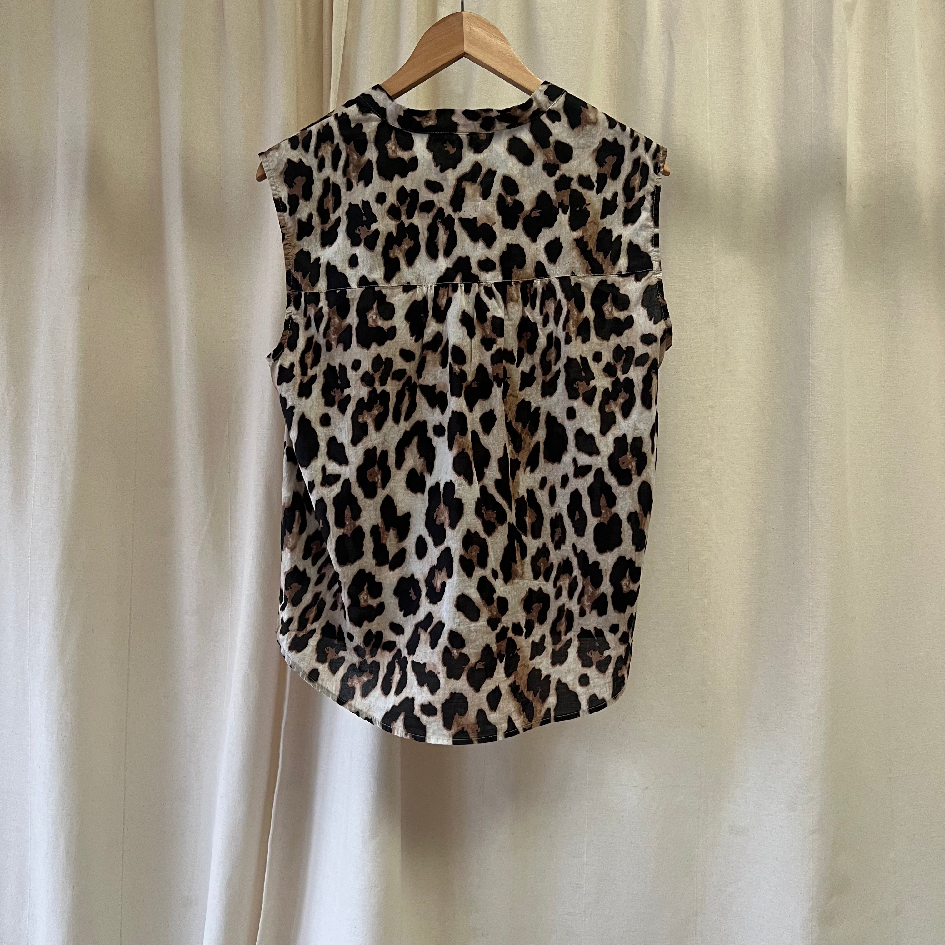 Leopard print sleeveless top on a hanger against a plain background