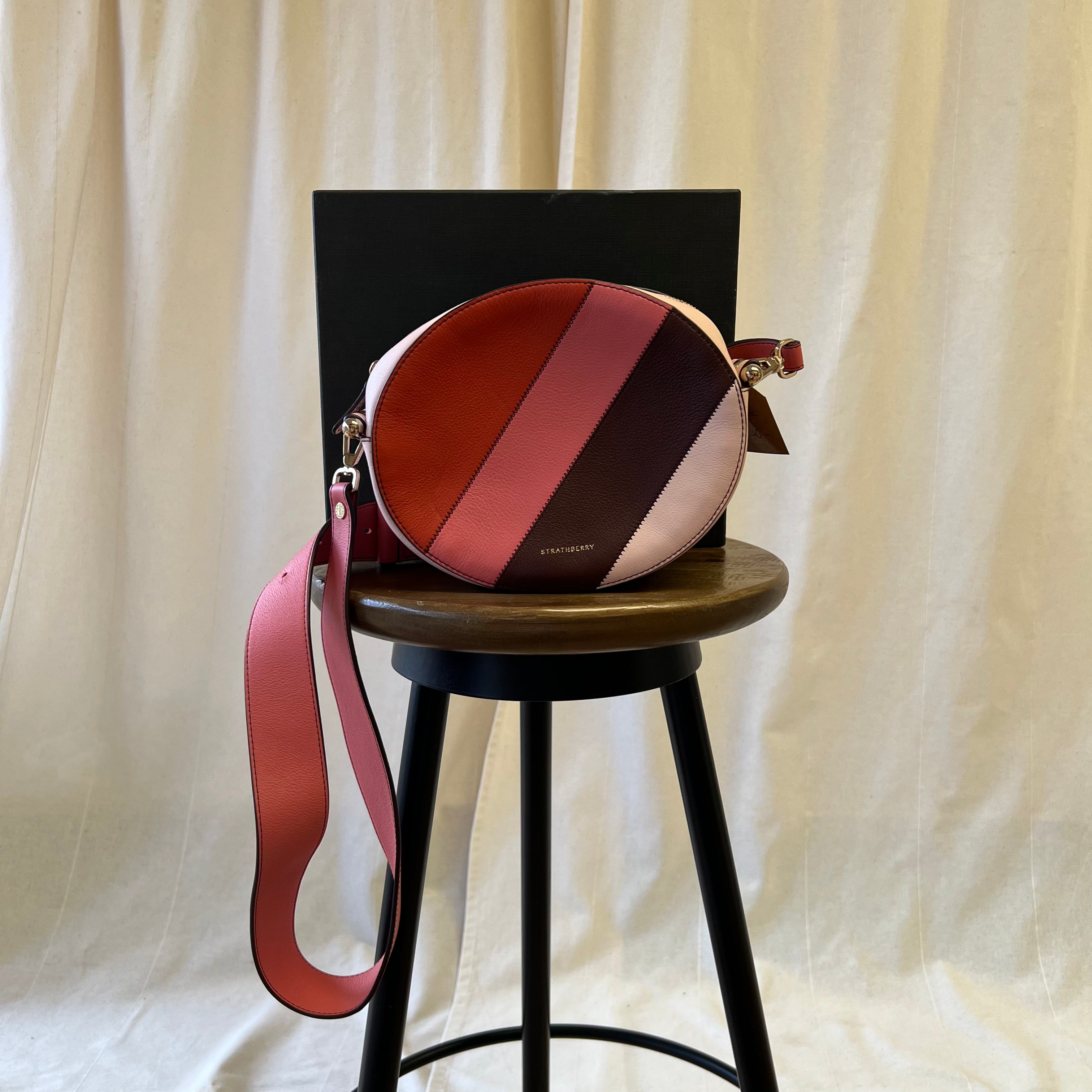 Strathberry pink toned across body oval shaped bag