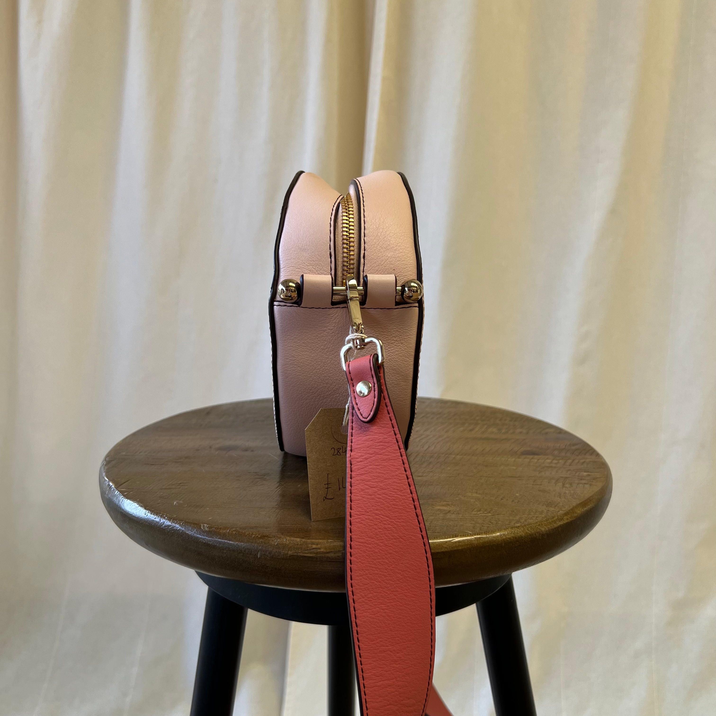 Strathberry pink toned across body oval shaped bag