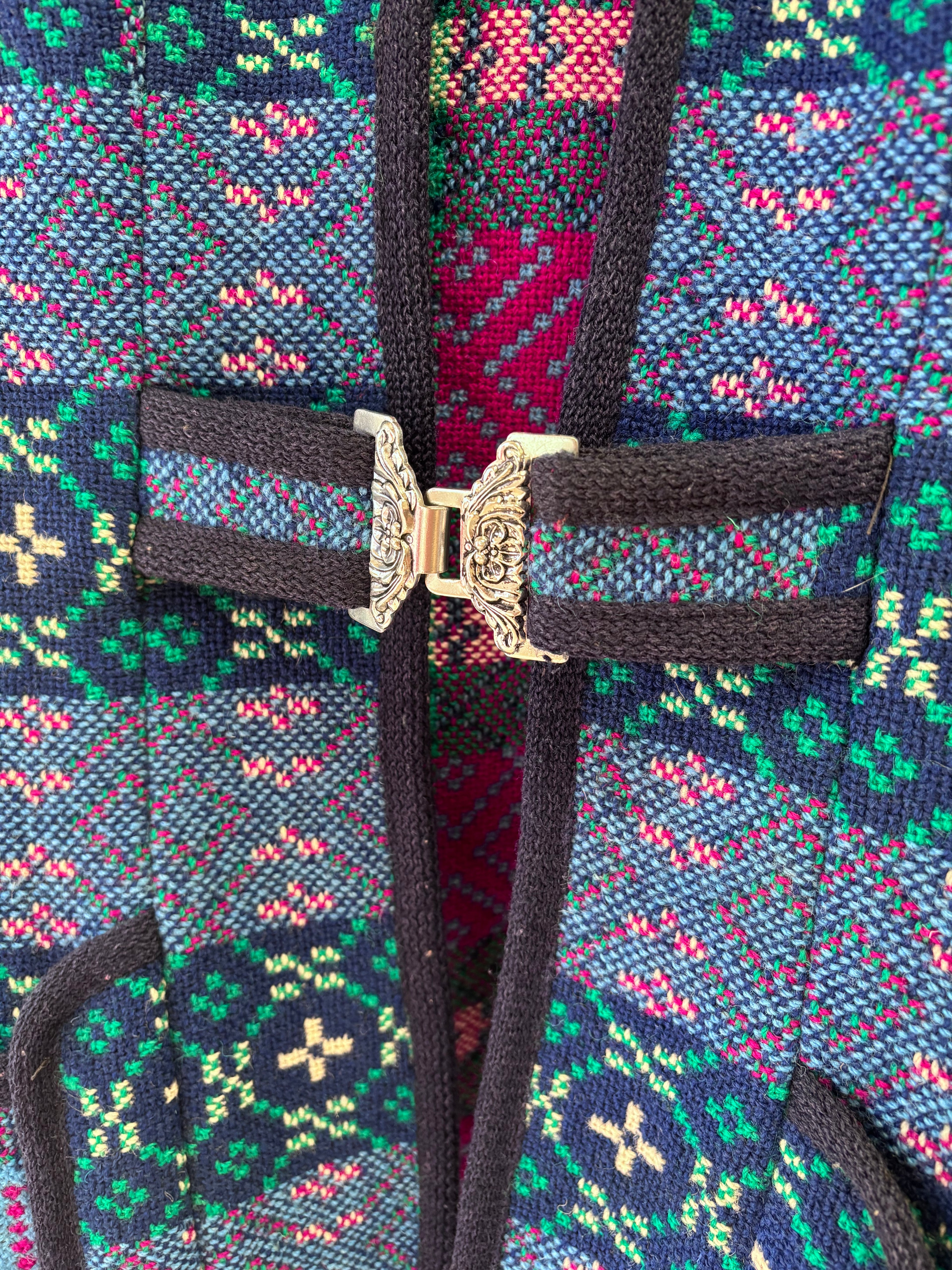 Close-up of a colorful woven vest with a decorative buckle.
