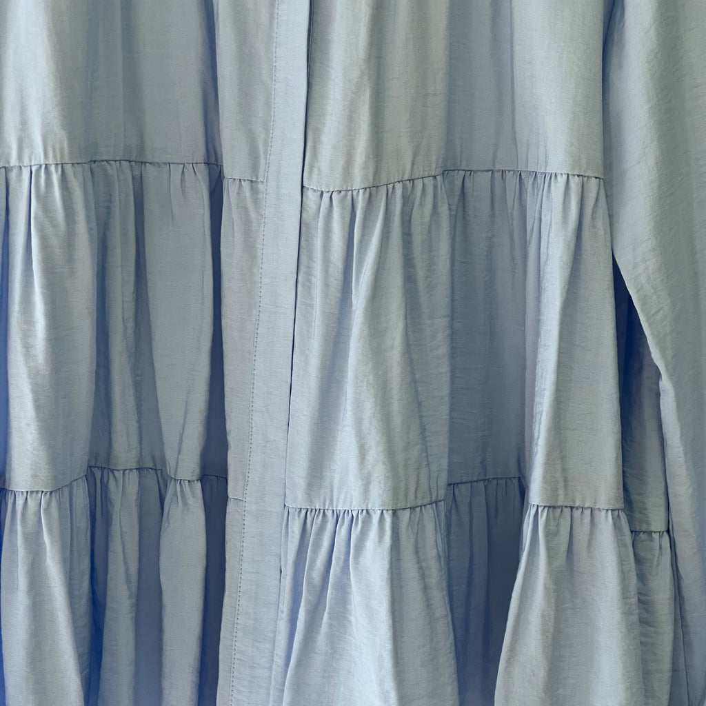 Close-up of a light blue curtain with ruffled layers