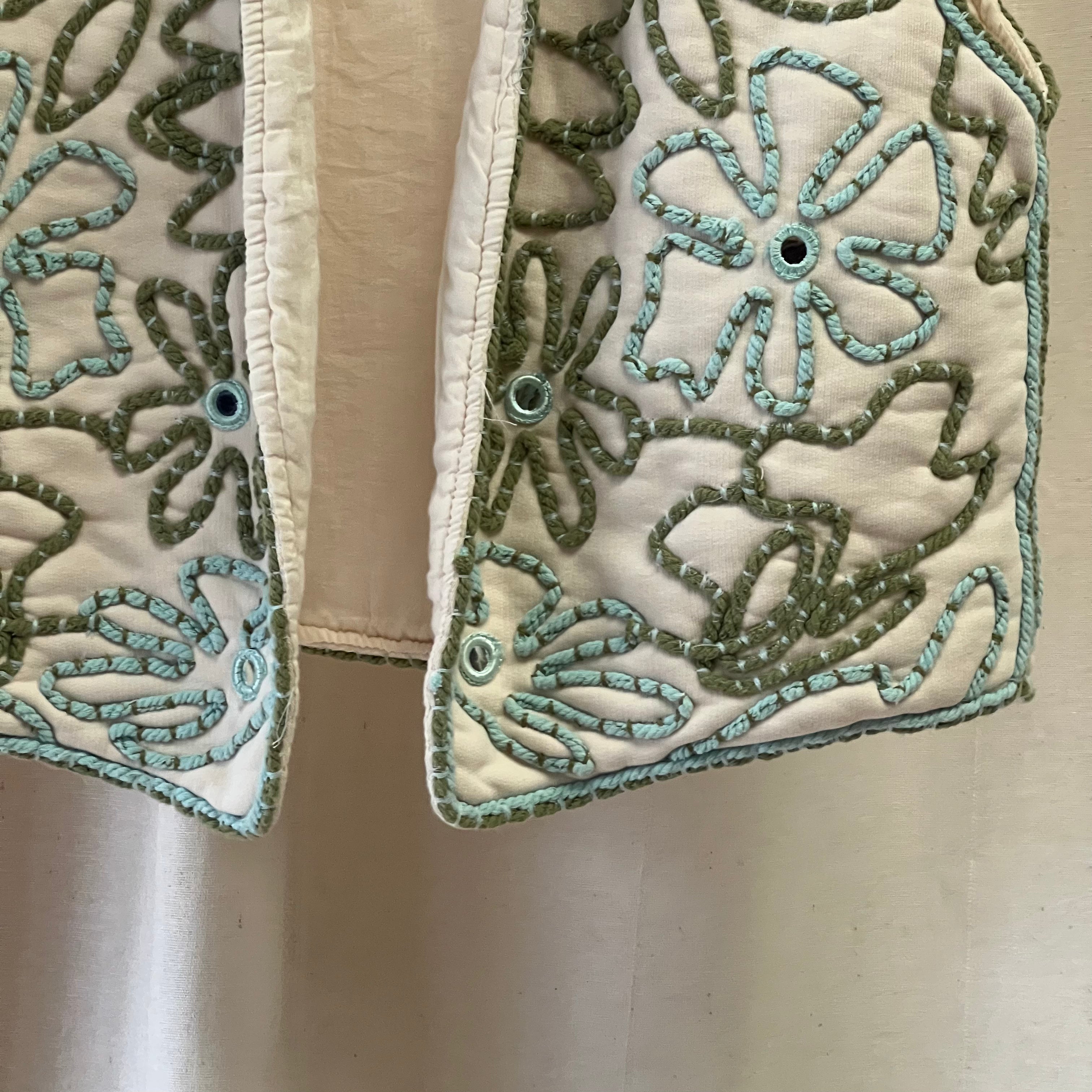 Close-up of embroidered fabric with floral patterns on a beige background